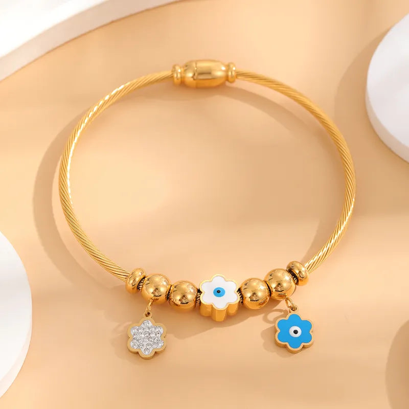 18 karat gold rope charm bracelet with enamel evil eye accents